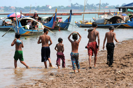 Children walk along the Mekong River in Phnom Penh on April 5. Riparian nations have pledged to step up cooperation over the river’s use amidst fears China's upstream dams are exacerbating a severe regional drought (AFP).