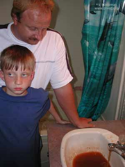 Kenny Stroud and his son ponder their contaminated water in their Rawl, Mingo County, West Virgina home. Photo by Vivian Stockman via blogs.wvgazette.com