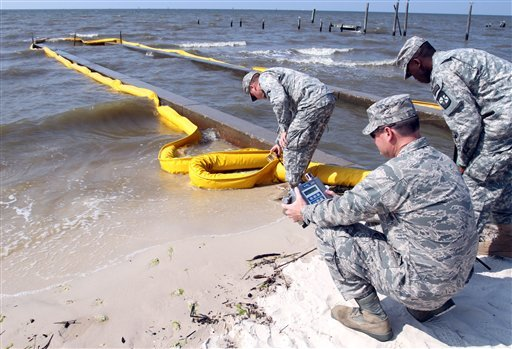 Lt. Col. Stephen McCrane, foreground, and Cadet Rodric Scott, right, look at the AreaRAE as Sgt. Jasen Rodgers takes a VOC, or volatile organic compunds reading of a boom in Waveland, Miss. Thursday, June 10, 2010. The three are with the 47th Civil Support Team-Weapons of Mass Destruction from Jackson, Miss. AP Photo / The Sun Herald, Tim Isbell
