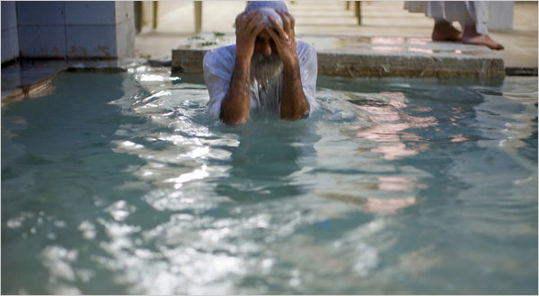 A man submerges himself in water from a tank during evening prayers at a temple in Basra, Iraq, because the river-fed canal outside was too polluted. Holly Pickett for The New York Times