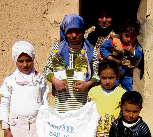 Syrians with food products procured through Ireland's donation of $900,000 to the World Food Programme. Syria is sweltering in an unseasonable heatwave which Damascenes are blaming on climate change.  Irish Times, June 25, 2010