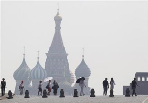 People walk along Red Square, with St. Basil's Cathedral seen through heavy smog caused by peat fires in out-of-city forests, in Moscow, July 26, 2010. REUTERS / Sergei Karpukhin