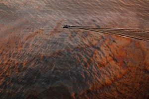 A boat motors through oil sheen from the Deepwater Horizon oil spill off East Grand Terre Island, where the Gulf of Mexico meets Barataria Bay, on the Louisiana coast, at sunset on Saturday, July 31, 2010. AP Photo / Gerald Herbert