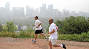 Smoke from B.C. forest fires blankets downtown Calgary as joggers John Dimaulo, left, and Mark Carter brave poor air quality on Aug. 20, 2010. Larry MacDougal / The Canadian Press