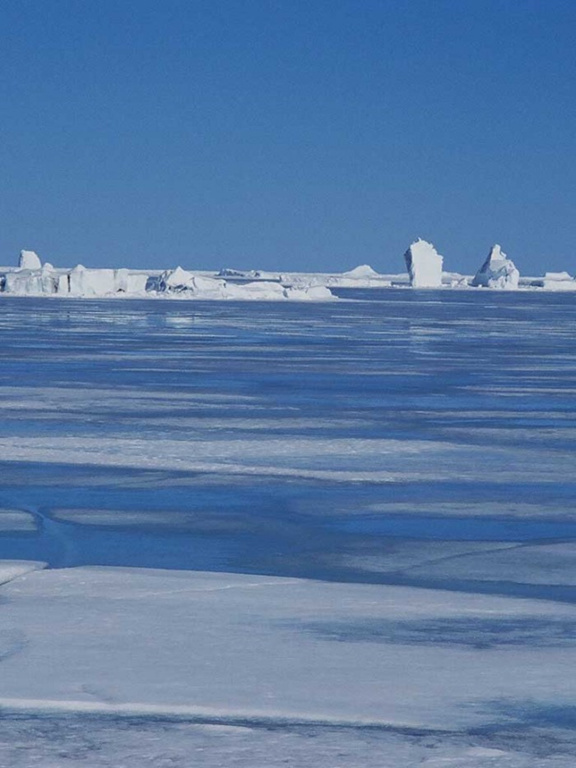 Meltwater ponds on sea ice off Coburg Island, Nunavut, Canada. Arctic warming has been associated with a rapid decline in Arctic summer sea ice extent. Sandy Briggs