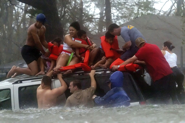 Bay St. Louis Emergency Management Agency volunteer crews rescue the Taylor family from the roof of their Suburban, which became trapped on U.S. 90 due to flooding during Hurrican Katrina on 28 August 2005. Ben Sklar / AP