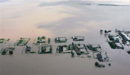 In this photo released by Korean Central News Agency via Korea News Service, houses and farmland are inundated by floodwaters in the North Koran city of Sinuiju on Saturday Aug. 21, 2010. North Korea's official Korean Central News Agency said that about a foot (30 centimeters) of rain had fallen since midnight and the Yalu, or Amnok as its known in Korean, swamped houses, public buildings and farmland in more than five villages near Sinuiju, the city opposite Dandong, China. AP / Korean Central News Agency via Korea News Service