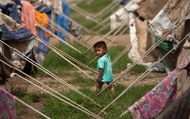 A young flood victim looks on at a relief camp in Nowshera in northwestern Pakistan on September 3, 2010. Pakistan's northwest, the first region to be hit by the floods and the most devastated, now has roads lined with tents and tens of thousands of displaced waiting to go home. REUTERS / Morteza Nikoubazl