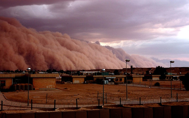 A massive dust storm cloud rolls over Al Asad, Iraq, just before nightfall on April 27, 2005. DoD photo by Corporal Alicia M. Garcia, U.S. Marine Corps.