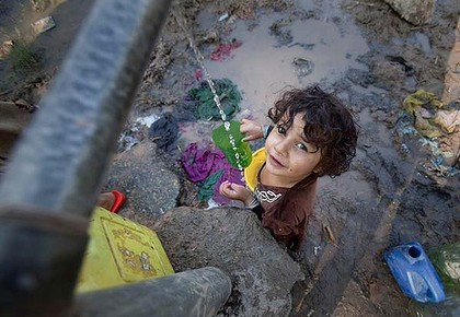 No relief ... a child collects water from a well at a camp for flood victims in Nowshera, Pakistan. Pneumonia remains a huge threat, especially to children, as temperatures plummet in December, 2010. Reuters