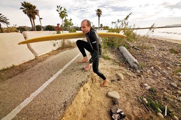 Jan Sovich of Ventura climbs up to the crumbling asphalt at Surfers Point. A bicycle path and parking lot are being moved 65 feet. Al Seib / Los Angeles Times / January 16, 2011