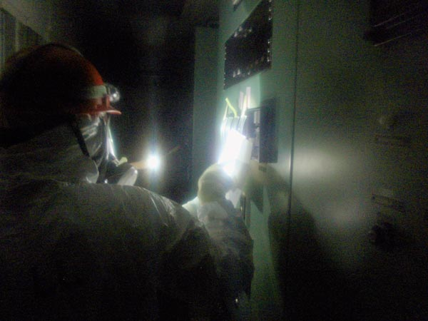 Workers continued to need flashlights to read gauges in the control room for Units 1 and 2 reactors at Japan's Fukushima Daiichi nuclear power plant, 23 March 2011. Photograph from Japan Nuclear and Industrial Safety Agency via AP