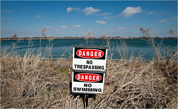 A sign warns against swimming in a holding lake in Texas, where Fountain Quail Water Management separates and cleans hydrofracking water. Matt Nager / The New York Times