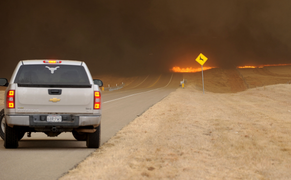 A truck that was headed towards Amarillo, Texas turns around to get away from the flames crossing FM 136 from the Potter County fire, Sunday, Feb. 27, 2011. Texas Forest Service spokesman Lewis Kearney said two wildfires joined about five miles south of Amarillo to destroy or damage the almost two dozen homes Sunday afternoon. AP Photo / The Amarillo Globe News