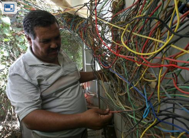 An Iraqi electrician checks last June the wires leading to a block of flats all connected to a generator which runs when the national power grid is down. Ali al-Saadi / AFP / Getty Images