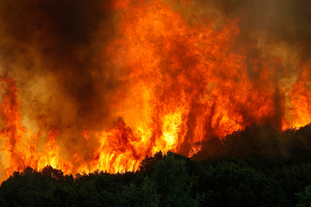 A running wildfire threatens a home on April 19, 2011 in Strawn, Texas. Getty Images / Tom Pennington / sacbee.com