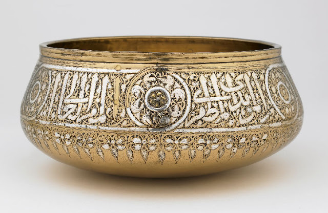 According to the elegant inscription encircling the rim of this fine beaten-brass bowl, it was made for the Mamluk sultan al-Malik al-Muzaffar, Saif al-Din Hajji, who ruled for only one year from 1347 to 1348. Like many other Mamluk vessels, the bowl's interior base is adorned with a fish-whirl design centered on a radiating sun disk. Egypt or Syria. 1346-1347 A.D. 10.3 x 23.5 x 23.5 cm. Courtesy of the Freer and Sackler Galleries, Smithsonian Institution; Lent by the Nuhad es-Said Collection.