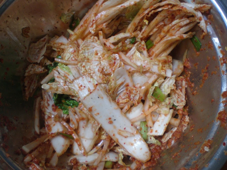 Napa cabbage is added to the same bowl