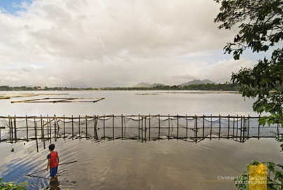 A boy tends a fishpen