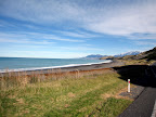 Beach on one side. Snow covered mountains on the other.