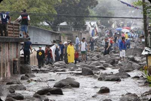 People walk in a street damaged by heavy rains001