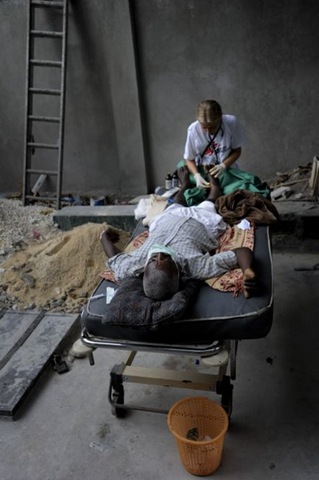 [Doctors Without Borders surgeon in #Haiti treats a man with a boken foot in a makeshift surgery room outside of the hospital. © Julie Remy[5].jpg]