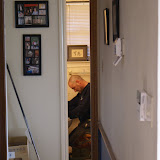 Sean installing the new toilet, as seen through my hallway