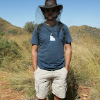 Netz vor dem Gesicht, hunderte Fliegen auf dem dunklen Shirt.