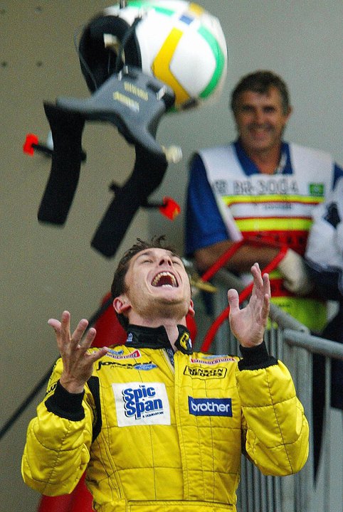 Джанкарло Физикелла подбрасывает шлем на Гран-при Бразилии 2003