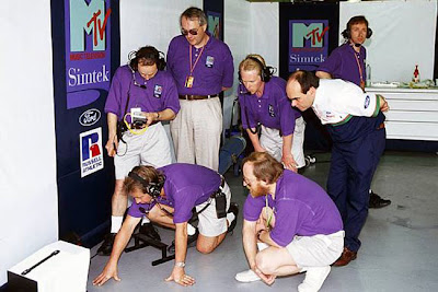 механики Simtek вокруг одного монитора на Гран-при Бразилии 1994