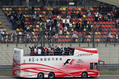 автобус с гонщиками проезжает мимо болельщиков на Гран-при Китая 2011