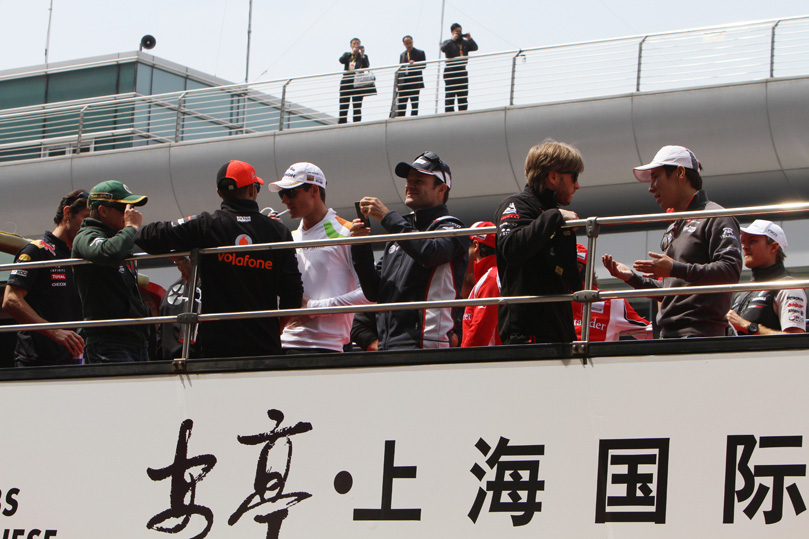 гонщики в автобусе на параде пилотов на Гран-при Китая 2011