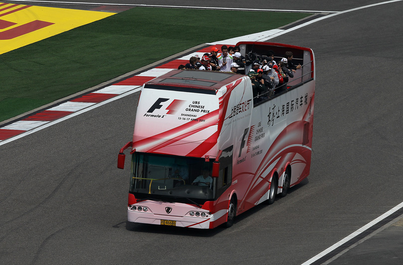 автобус с гонщиками проезжает по Шанхайской трассе на параде пилотов Гран-при Китая 2011