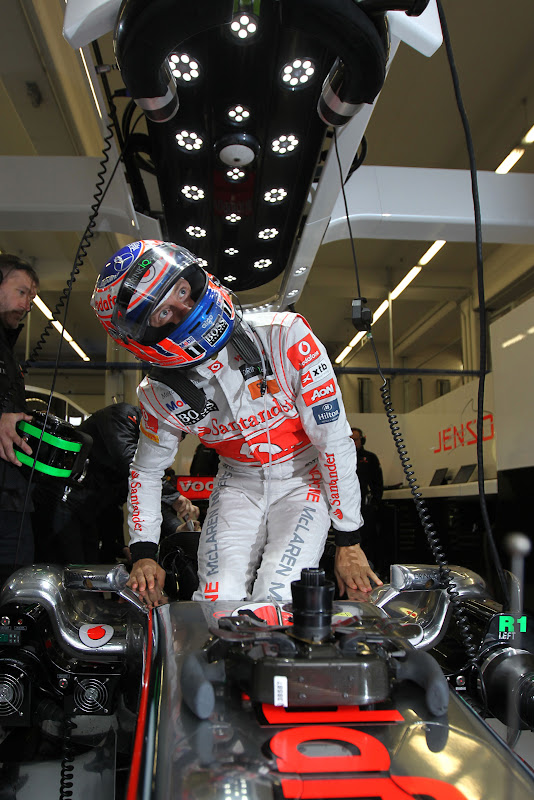 Дженсон Баттон вылазит из кокпита McLaren в боксах команды на трассе Истамбул-Парка на Гран-при Турции 2011