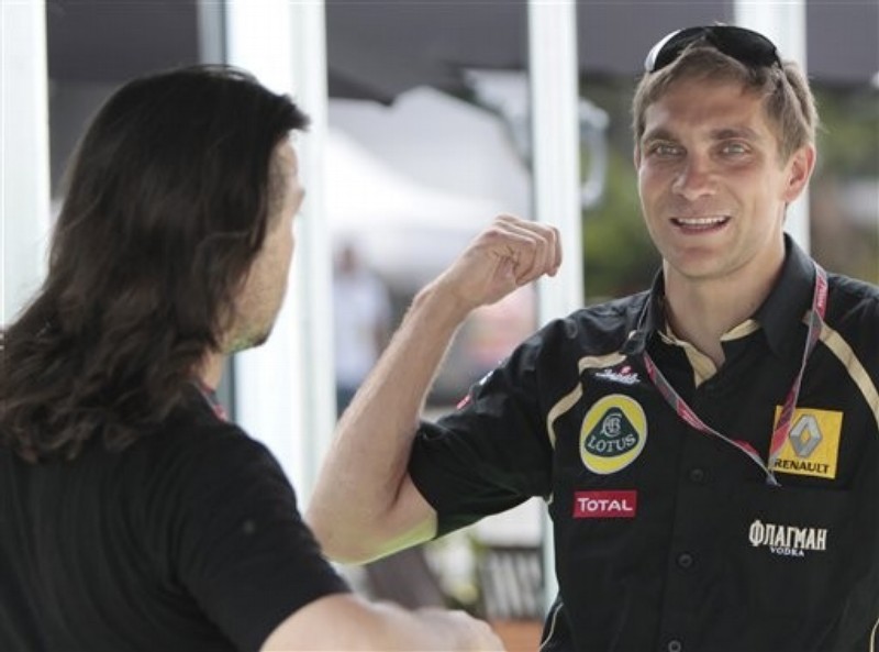 жестикулирующий Виталий Петров разговаривает с кем-то на Гран-при Малайзии 2011
