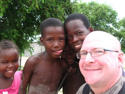Dave Fox with curious kids in the village of Sankoyo Botswana