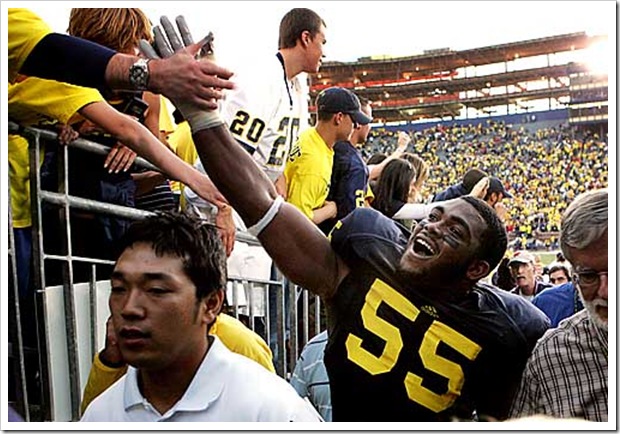 (caption) Michigan defensive end Brandon Graham high fives fans as he heads to the locker room after the Wolverines' victory.  *** Michigan rallies back from a 19-0 deficit to stun the ninth-ranked Wisconsin Badgers 27-25, giving new head coach Rich Rodriguez a victory in his first Big Ten game. *** The Michigan Wolverines (1-2) host the 9th-ranked Wisconsin Badgers in U-M head coach Rich Rodriguez' first Big Ten game. Photos taken on Saturday, September 27, 2008.  ( John T. Greilick / The Detroit News )




