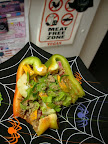 Half nommed bell pepper boat filled with nut/veggie pate, celery leaves, rainbow chard stems, cucumber, and marinated/dehydrated squash chunks