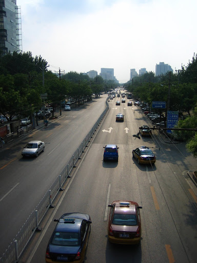 Looking west down Gongti Beilu from a pedestrian walkway, under a rare blue sky.
