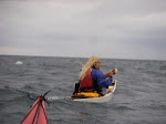 Lori using a sweep stroke to point her Betsie Bay Aral downwind. The nose of my Nigel Foster Silhouette is visible in the bottom of the shot. keithwikle.com
