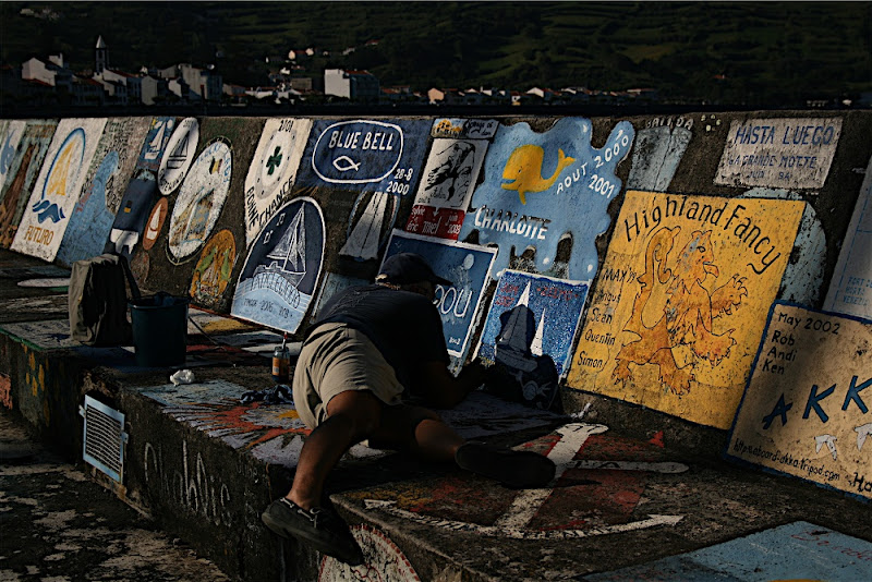 Sailor painting the walls at the Marina of Horta - Island of Faial