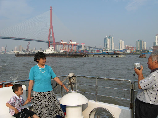 Family taking picture with the Nanpu Bridge in the background