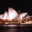 Closeup night view of the Sydney Opera House across Sydney Cove from Circular Quay near The Rocks