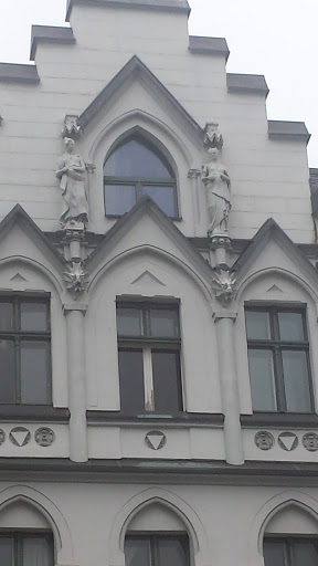 Zwei Statuen schauen vom Dach