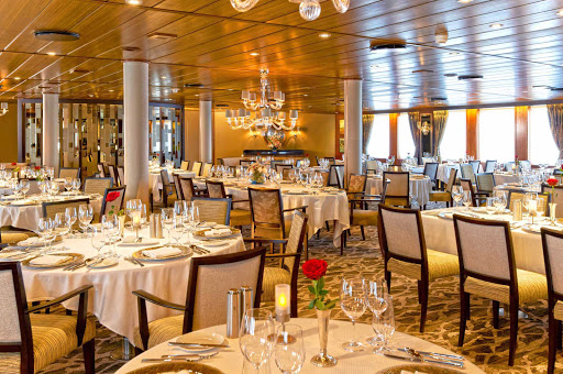 Wind Star's main dining room, AmphorA, is located on deck 3, accented with warm wood finishes and luxurious booths, with many tables for two and four passengers.