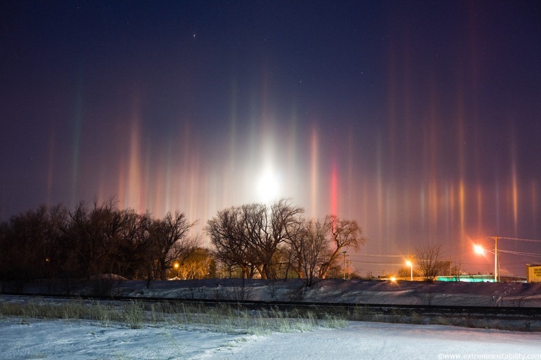 Arctic air combines with river steam and a corn milling plant's steam to produce light pillars over Blair Nebraska, thanks to ice crystals floating in the air from the steam sources.  A setting moon adds to the scene, creating a light pillar of its own.  