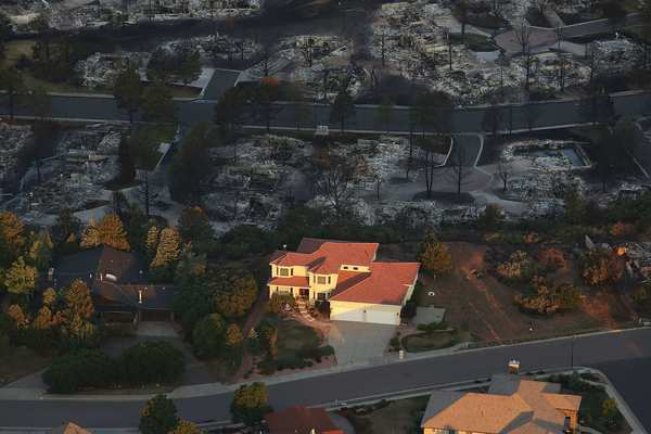 Destroyed homes sit beside a home left untouched by fire in a neighborhood affected by the Waldo Canyon fire on 30 June 2012 in Colorado Springs, Colorado. Spencer Platt / Getty Images