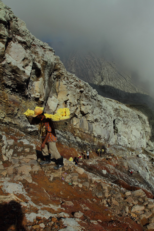 The steep and narrow climb with the sulphur load from the Ijen Crater, Indonesia