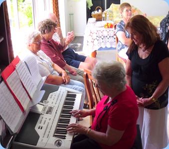 Barbara Powell trying out the Korg whilst our host, Delyse Whorwood, watches on and enjoying Barbara's playing.