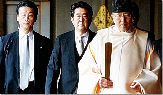 Japan's Prime Minister Shinzo Abe (C) is led by a Shinto priest as he visits Yasukuni shrine in Tokyo December 26, 2013.